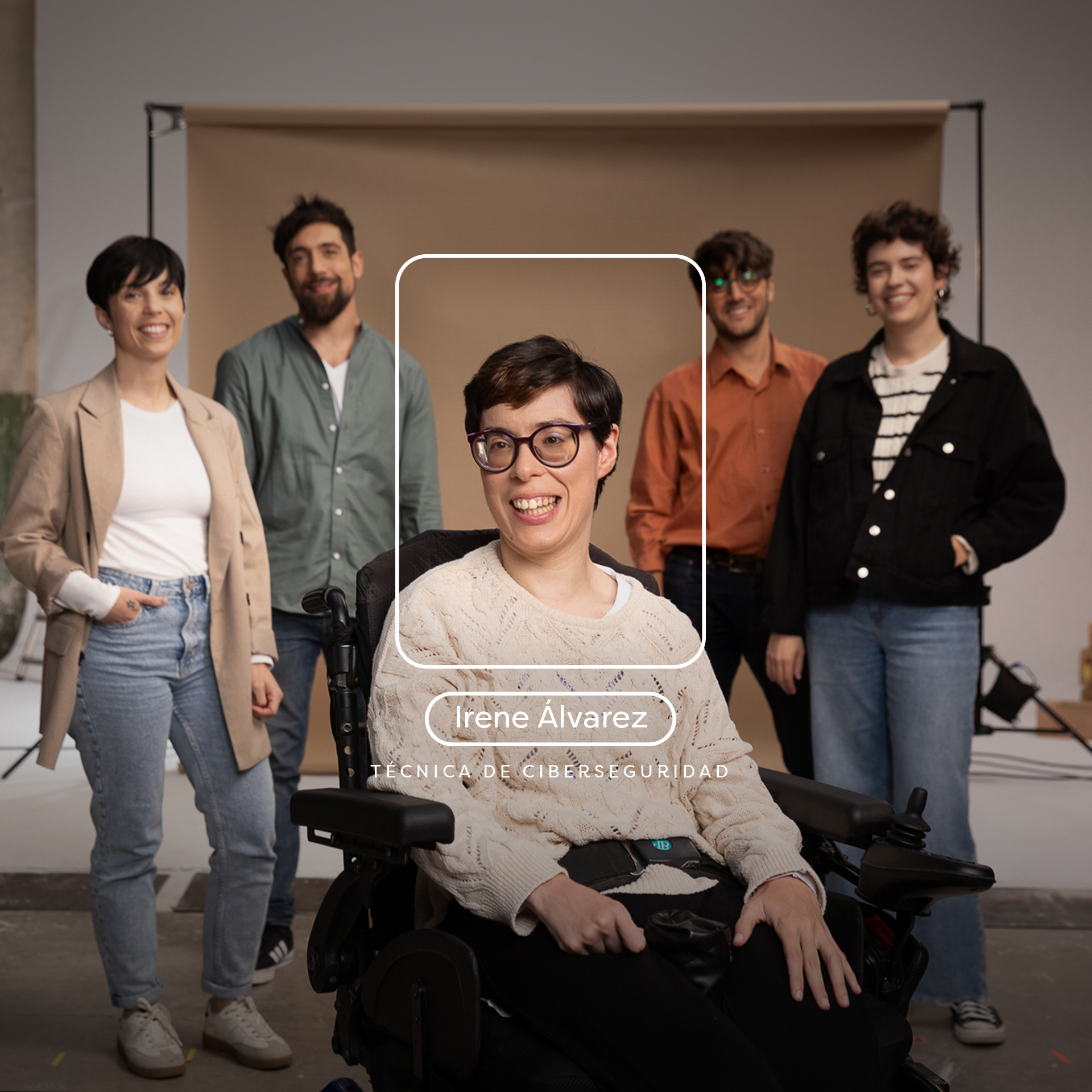 Grupo de personas en un estudio fotográfico con cuatro personas detras y una chica en silla de ruedas con gafas, pelo corto y jersey destacando delante