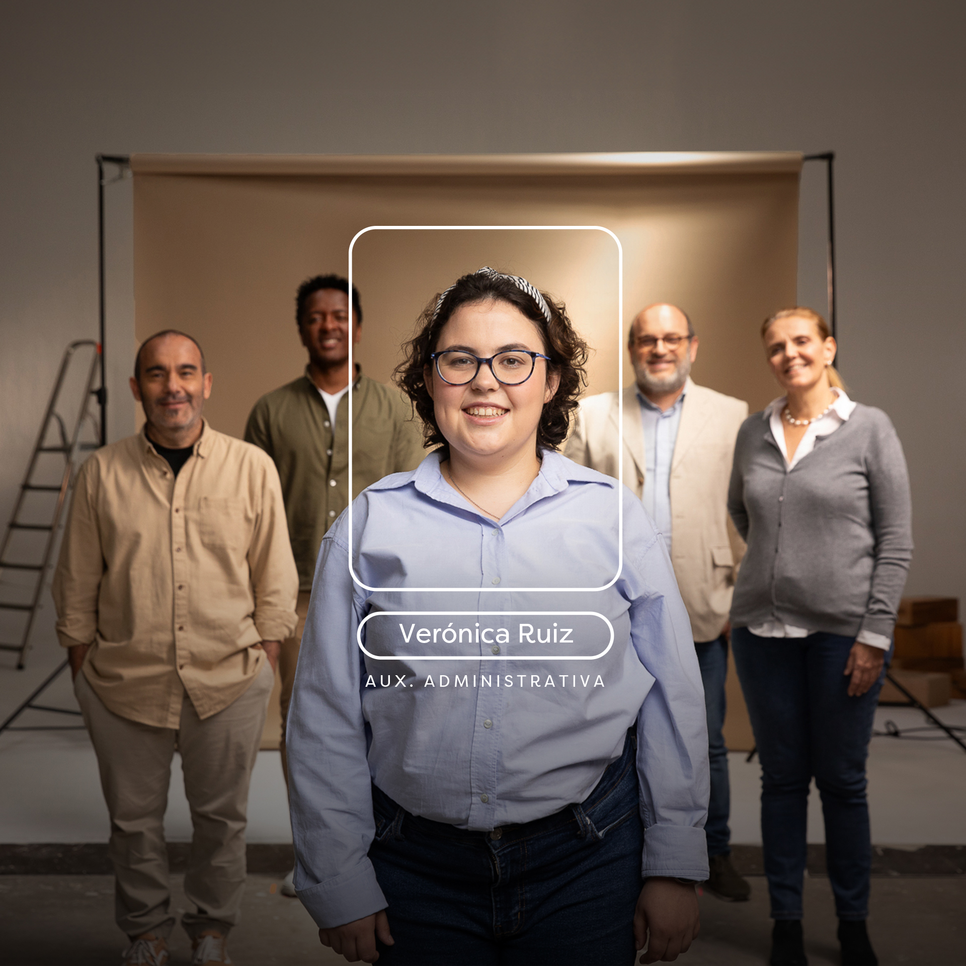 Grupo de personas en un estudio fotográfico con cuatro personas detras y una chica con camisa, gafas y pelo rizado destacando delante